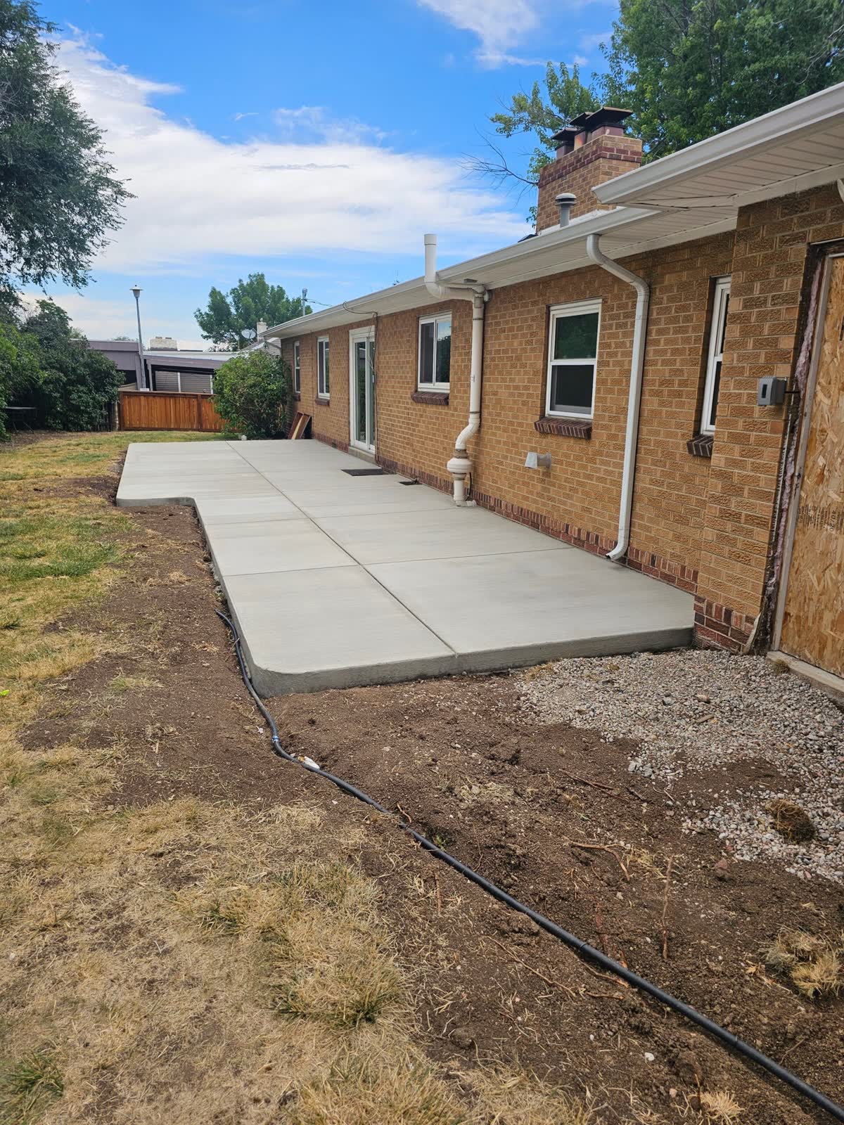 A long backyard patio along a brick house