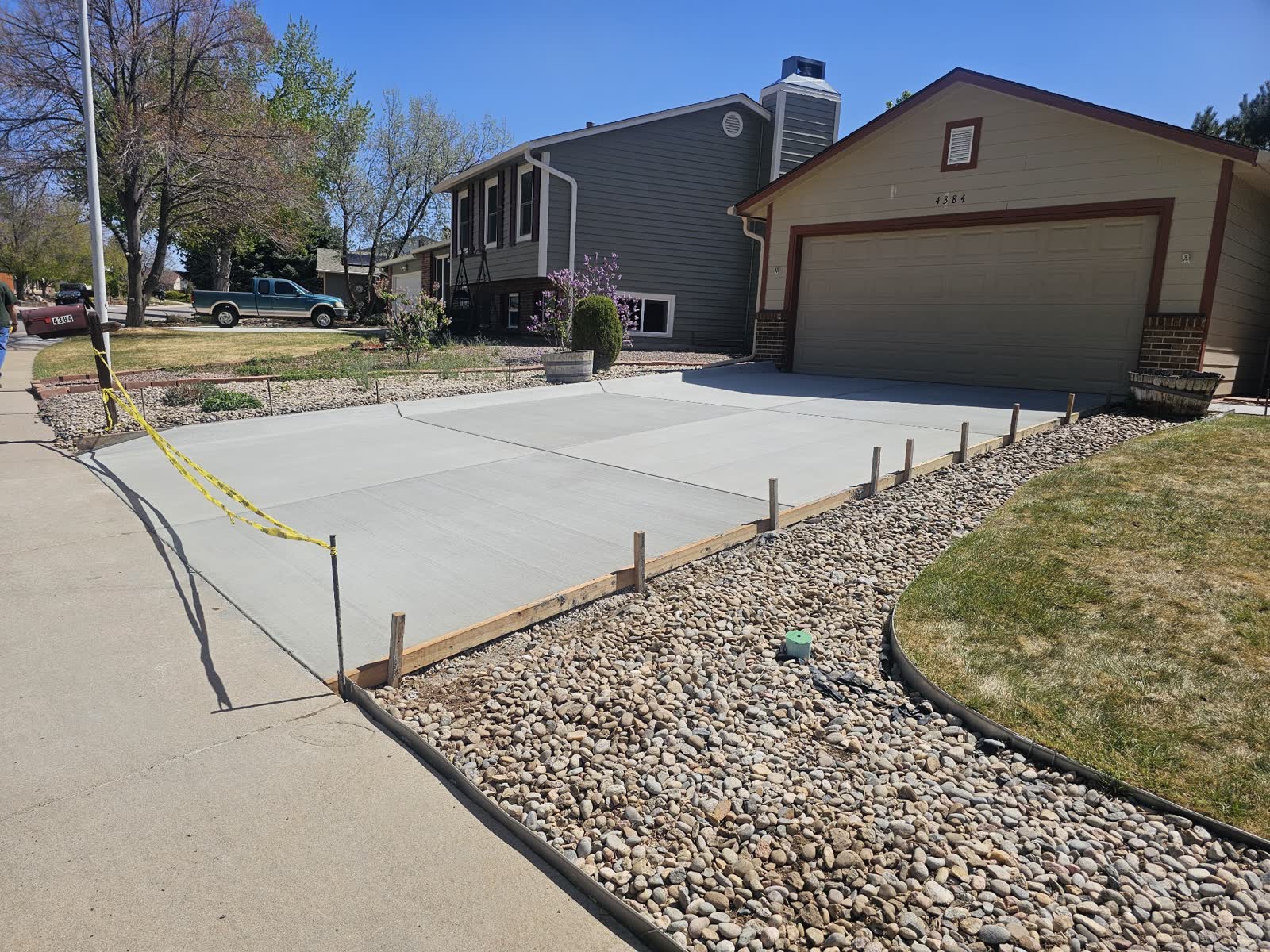 A new driveway curving past a rock bed to a garage