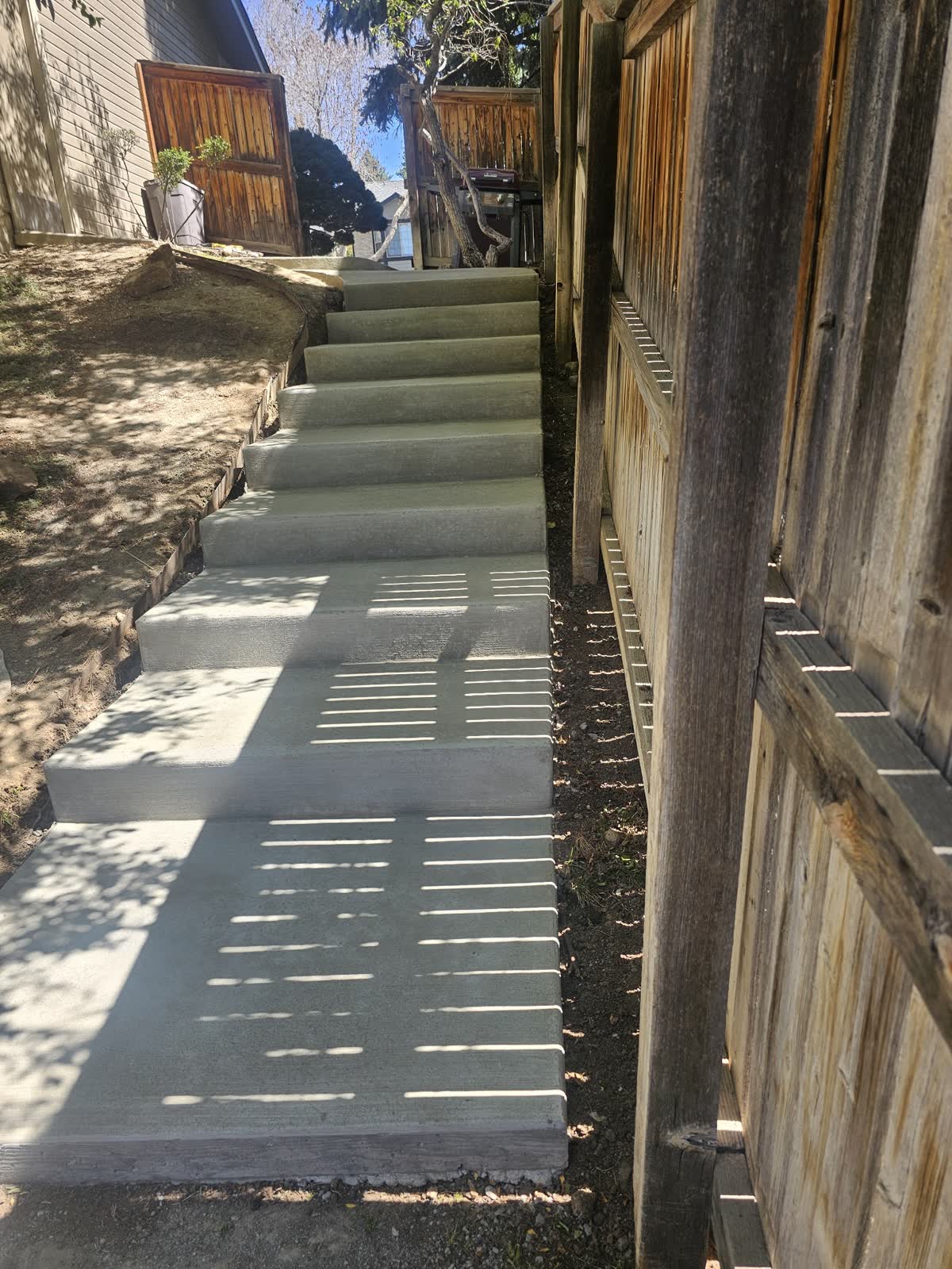 Concrete steps running beside a wood fence