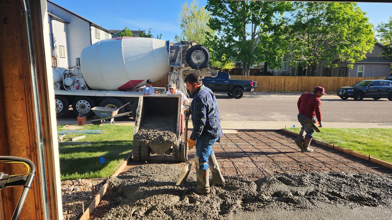 Concrete from a mixer truck being wheeled into the driveway forms
