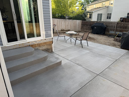 A concrete patio and steps where an old wooden deck used to be
