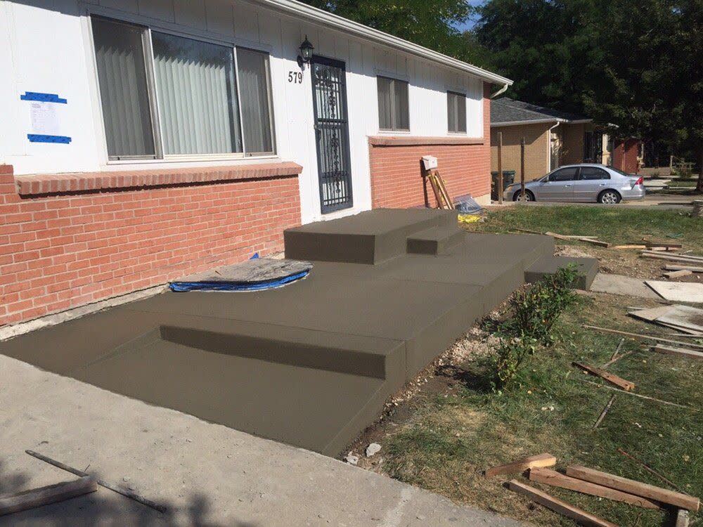 A front porch and steps freshly floated at a brick house