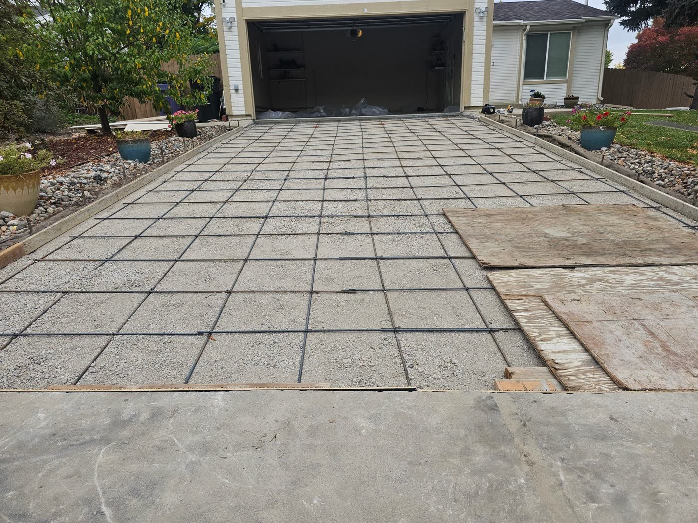 A full rebar grid tied out across a driveway before the pour